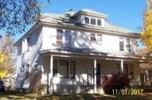 Two-story white house with a porch, large windows, and a gabled roof, surrounded by trees with autumn foliage. Date stamp in the lower right corner reads 11/01/2017.