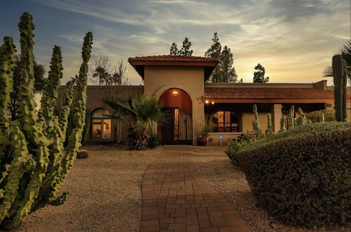 Best short-term rental markets Scottsdale, AZ A Spanish-style house, with archways, decorative lighting, and a terracotta roof, serves as an ideal getaway in the vibrant short-term rental markets. Surrounded by desert landscaping and cacti under a cloudy sky, this charming abode offers a serene escape.
