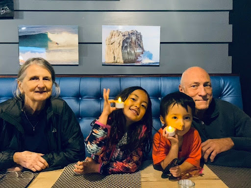 Grandparents sharing dinner with two grandchildren, the kind of time financial freedom makes possible